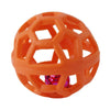 An orange, honeycomb-patterned rubber dog chew ball with a pink bell inside.