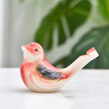 A ceramic whistle shaped like a colorful water bird, featuring pink and black tones, resting on a white surface.