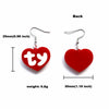 A pair of red acrylic heart drop earrings with silver ear wires shown from the back.