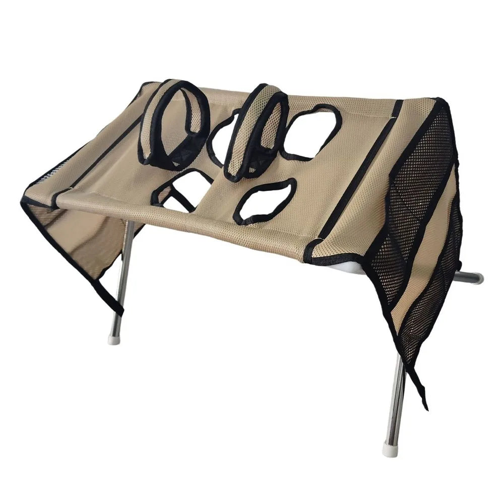 A beige foldable pet grooming hammock with mesh sides and black straps, designed for bathing and nail trimming.