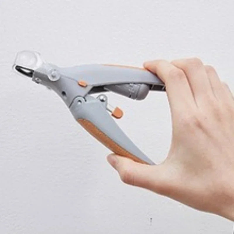 Una mano sostiene unas tijeras para uñas grises con mango de madera sobre un fondo blanco.