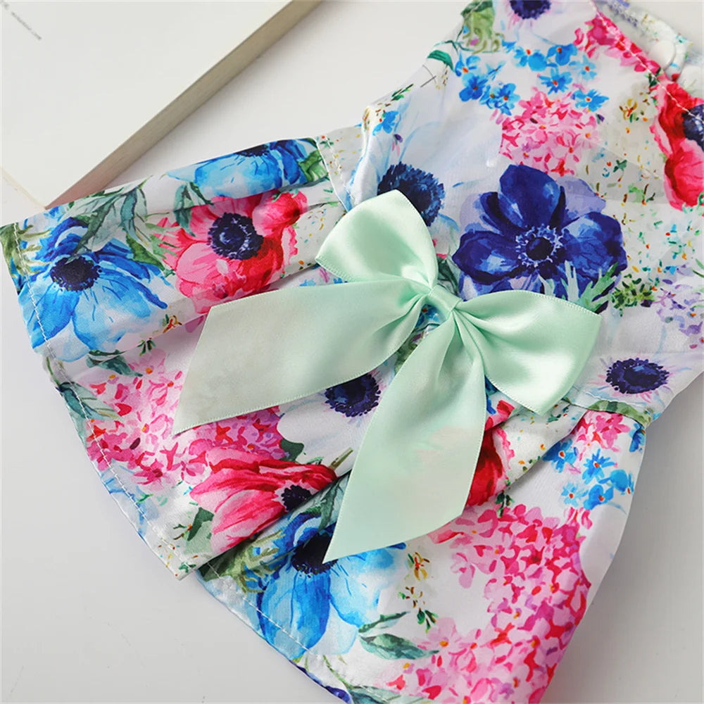 Lightweight summer skirt featuring a floral print with pink, blue, and red flowers and a pale green ribbon bow.