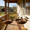 A retro wood grain bird feeder with a hanging iron chain suspended in front of a window.