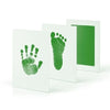 White framed art showing a green handprint and footprint on the left, and a green rectangle on the right.