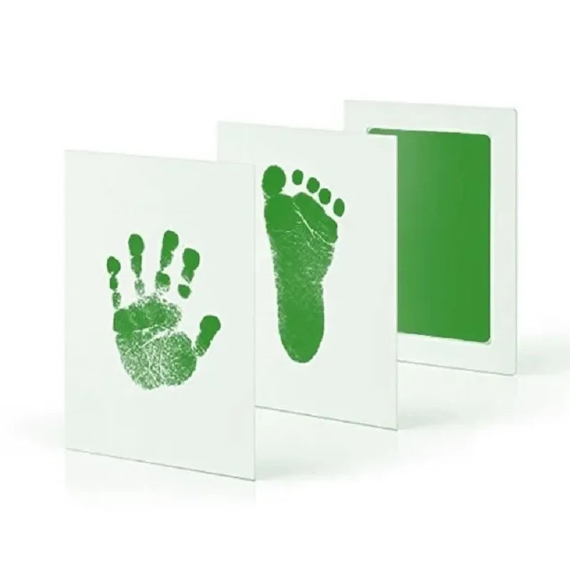 White framed art showing a green handprint and footprint on the left, and a green rectangle on the right.