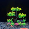 Un árbol miniatura de plantas acuáticas artificiales de color verde brillante sobre una superficie de piedra gris oscura.