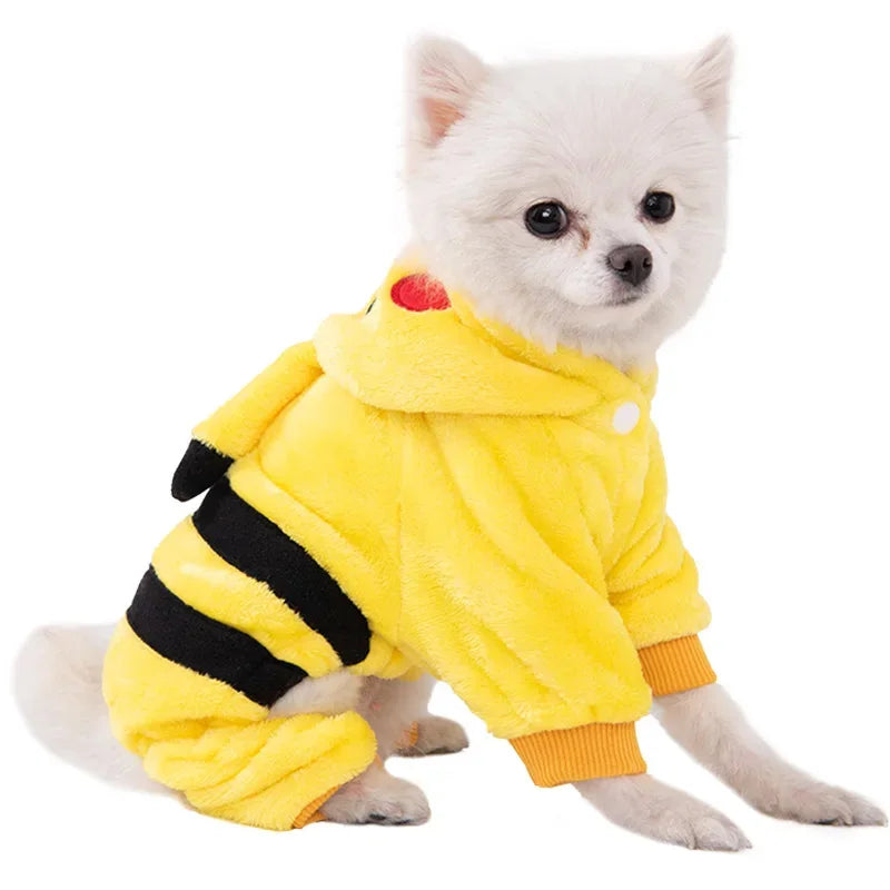 Un petit chien blanc portant un sweat à capuche jaune avec des rayures noires.