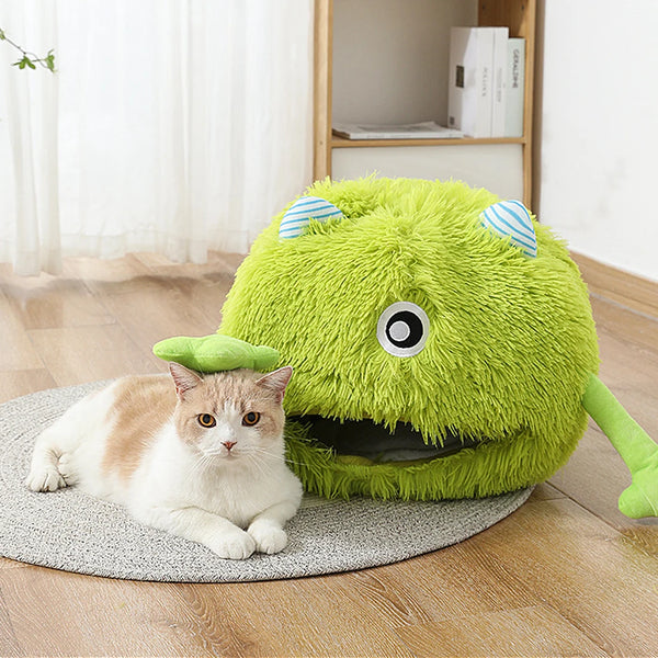 A bright green plush monster toy with large eyes and striped ears resting on a gray mat.