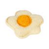A single boiled egg with a bright yellow yolk resting on a white, porous natural loofah.
