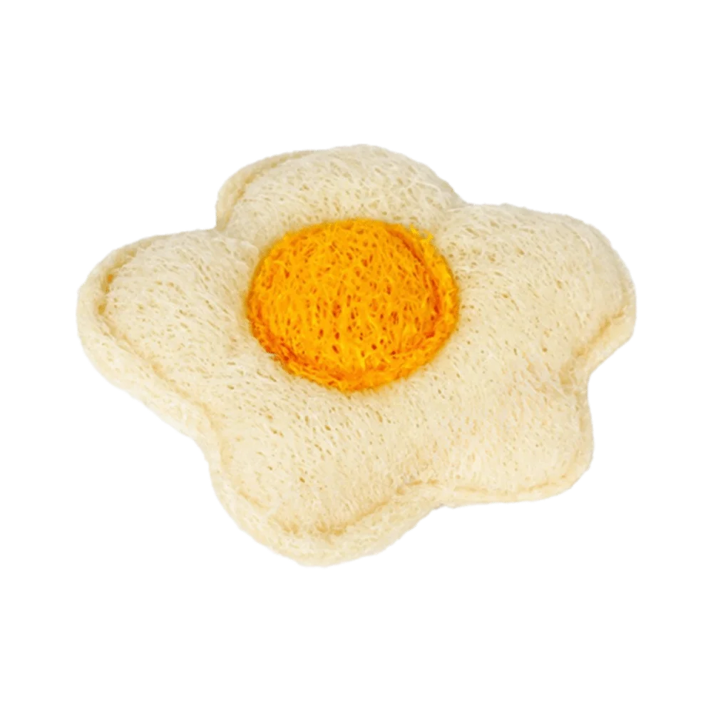 A single boiled egg with a bright yellow yolk resting on a white, porous natural loofah.