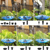 A solar powered water fountain featuring a blue ceramic bowl spraying water in a garden setting.