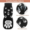 Black knitted dog socks with a white pawprint design showing the sole and toe area.