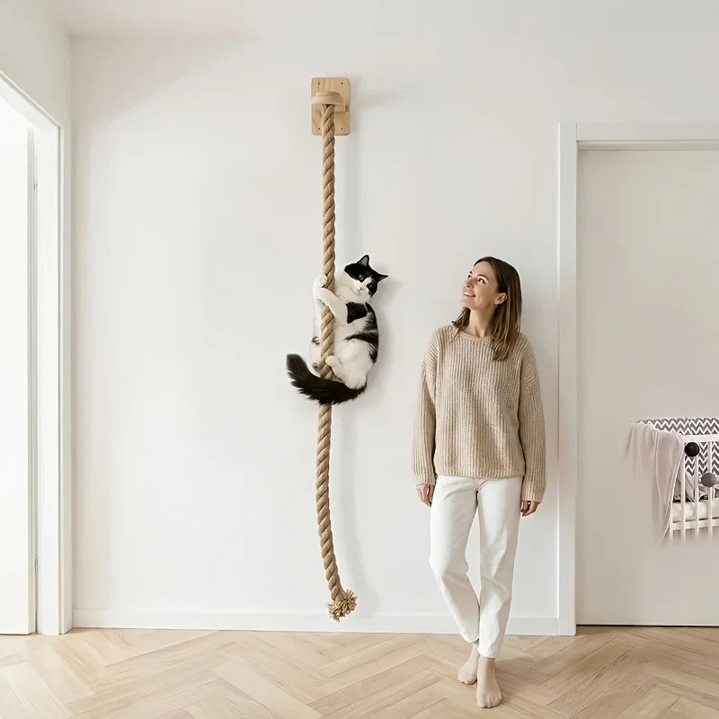 A woman stands next to a white cat scratching post mounted on the wall.