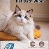 A fluffy white cat is sitting on a yellow cushion next to blue pet bath wipes and gloves.