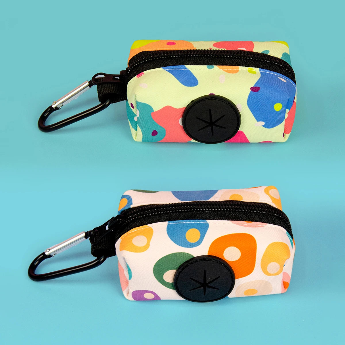 A colorful, patterned fabric pouch with a black zipper and clip is shown against a light blue background.