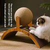 A cat is relaxing on a wooden scratching post with a large, round sisal ball for climbing.