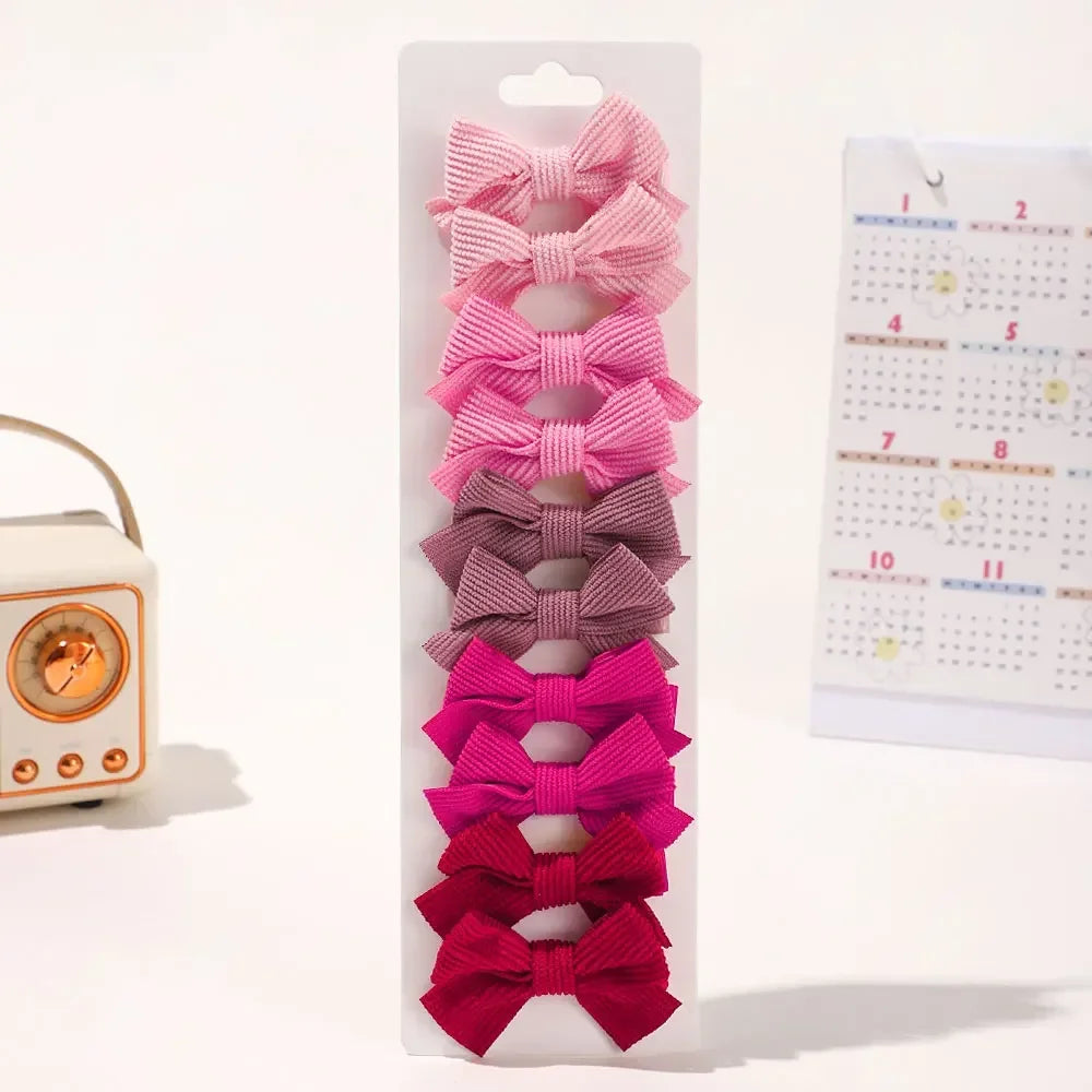 Pince à cheveux en ruban rose et magenta, présentées dans une gaine en plastique transparent.