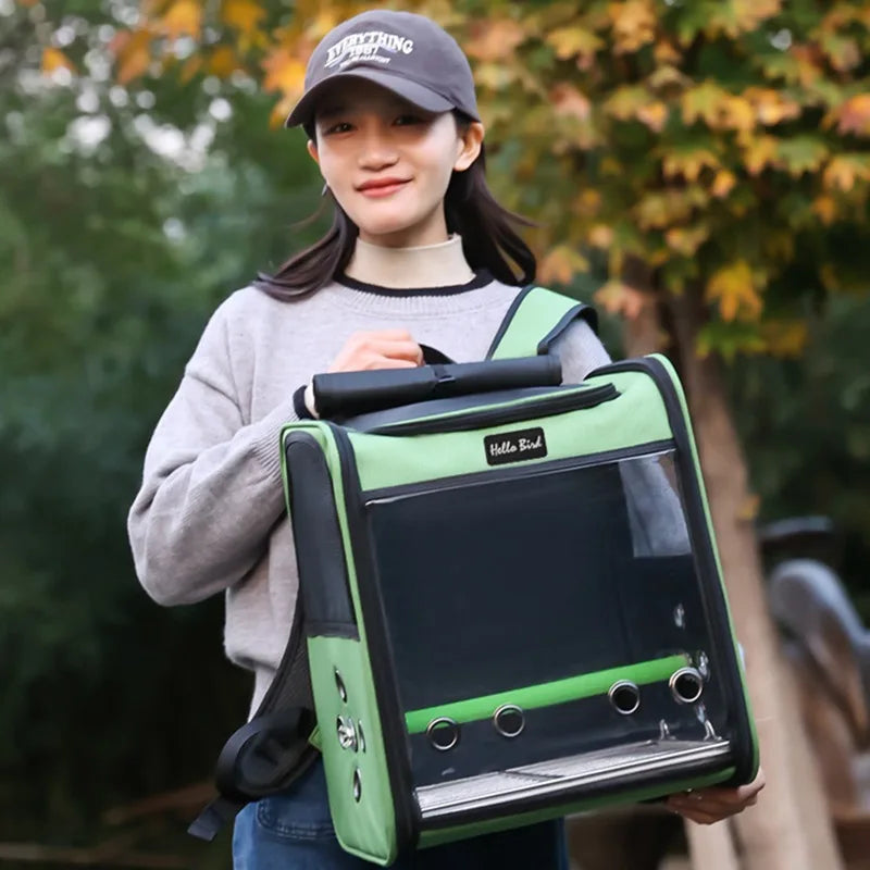 A young woman holds a green ventilated bird travel backpack with a perch and feeding cups.