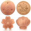 Un ensemble de disques pour bain d'oiseaux en cuivre, incluant un disque rond et un disque en forme de fleur.
