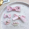 Pink bow hair accessory featuring pearl and rhinestone accents for children's hair