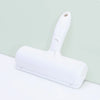 A white reusable pet hair remover brush with a handle is shown against a light green background.