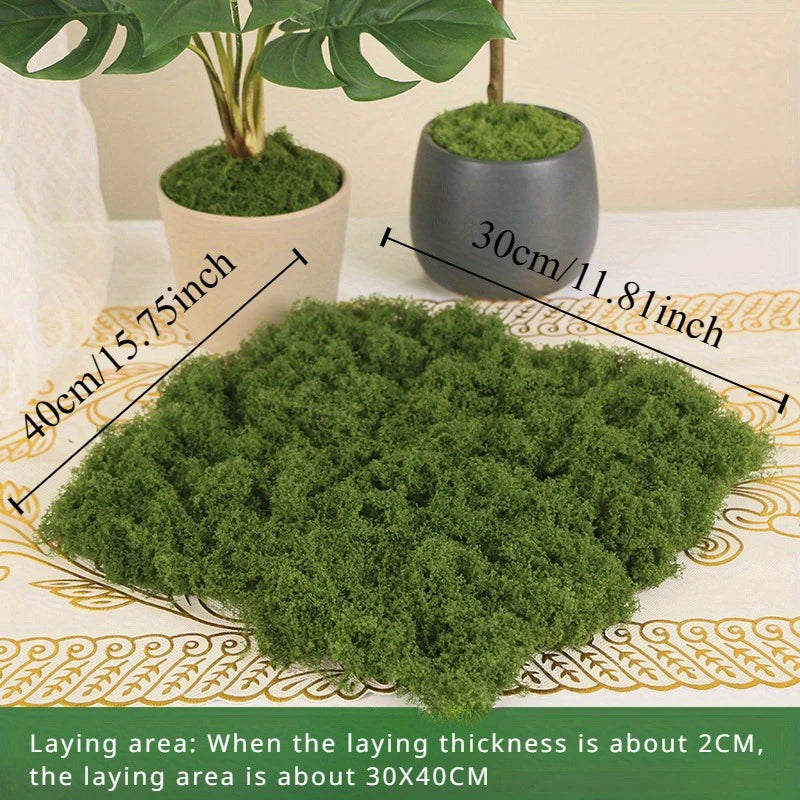 A pile of green preserved moss used for crafts and decoration, shown next to a potted plant.