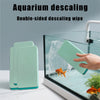 A double-sided teal silicone descaling wipe used for aquarium cleaning inside a glass tank.