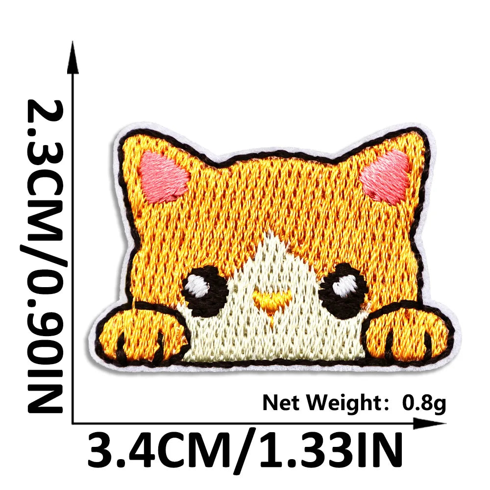 An embroidered patch of a cute orange cat face with white accents on a beige background.