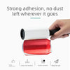 A hand is holding a white and red lint roller, demonstrating strong adhesion and ease of use.