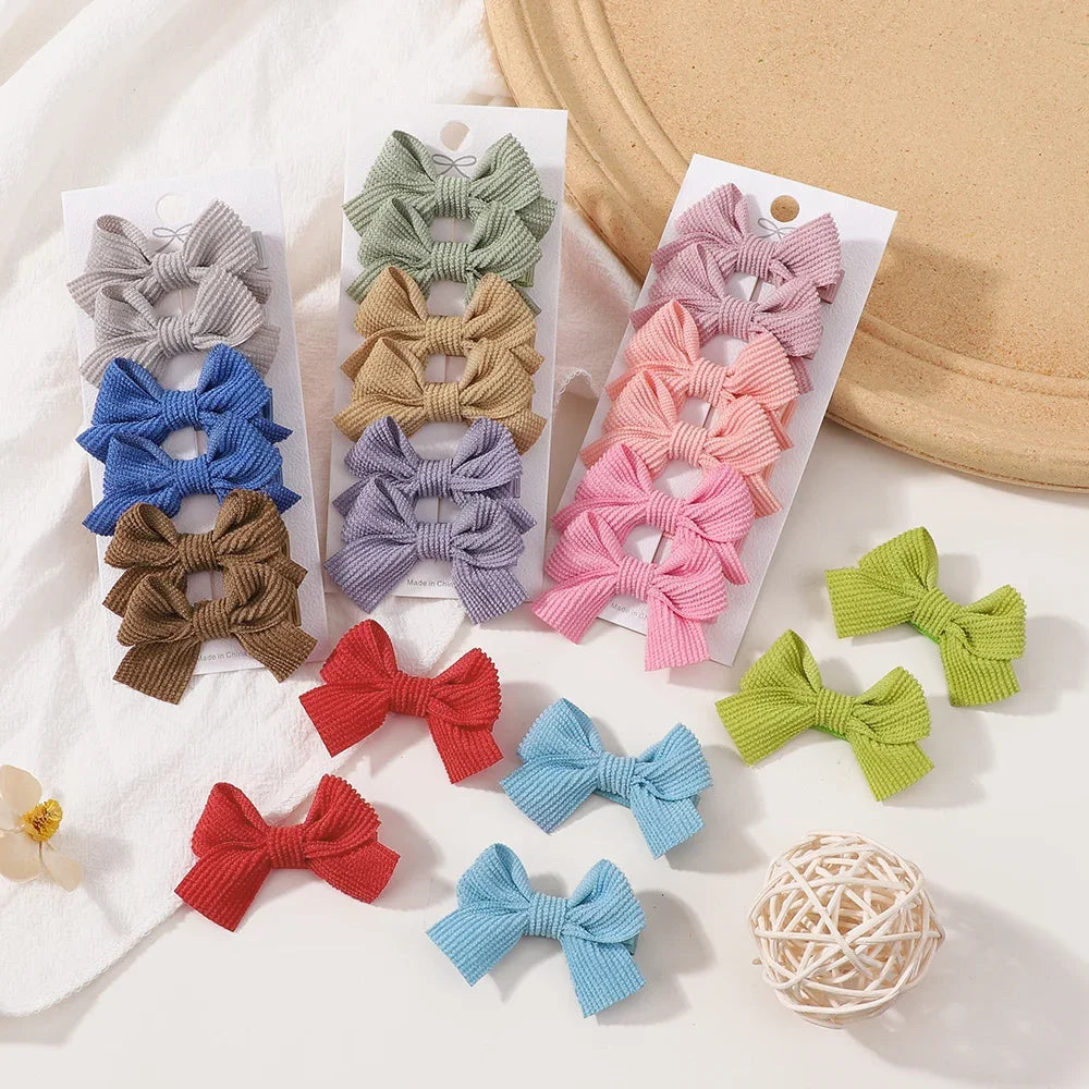 Assortiment de pinces à cheveux en ruban mignons dans diverses teintes de vert, violet, rose et bleu, présentées sur des cart