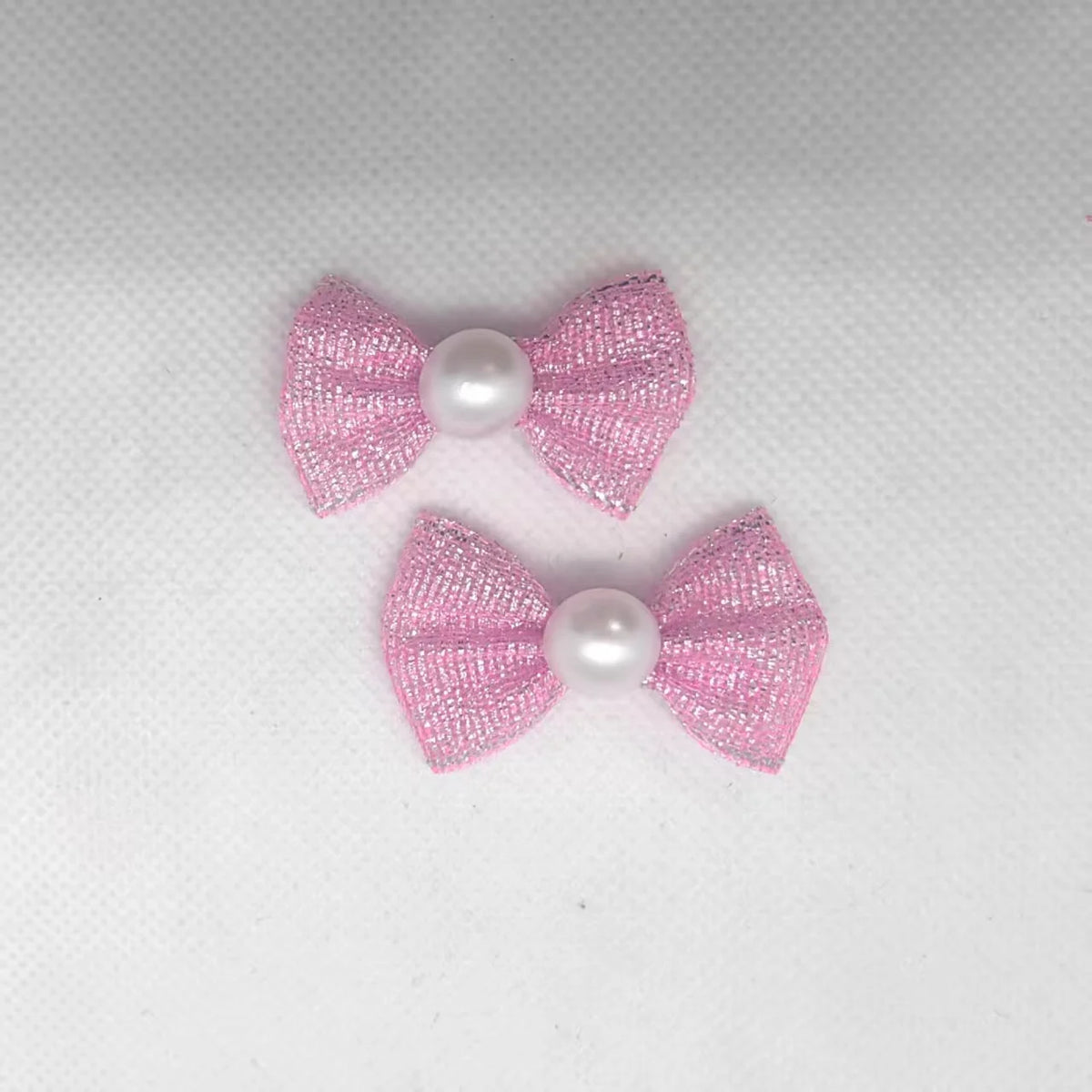 Ein Set aus drei rosa und weißen Puppenhund-Bow-Knoten für das Tierpflegegrooming.