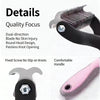 Close-up view of a stainless steel pet hair remover comb with a round head design and a pink handle.