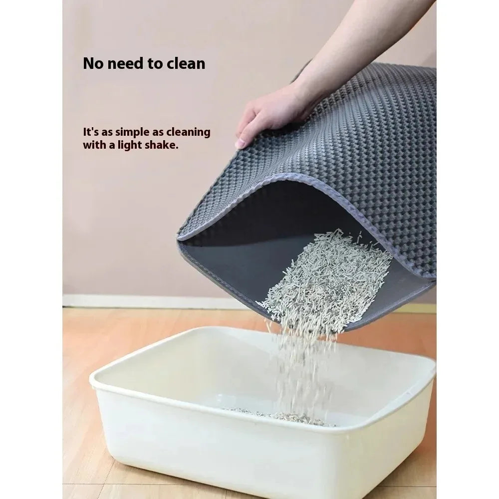 A hand is shaking a gray double layer cat litter mat into a white plastic container.