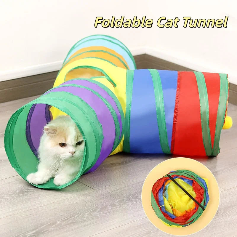 Buntes, faltbares Katzentunnel mit gestreiftem Stoff, einer kleinen weißen Kätzchen darin.