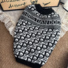 A black and white knit sweater featuring a repeating dog motif pattern.