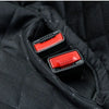 Close-up view of a black fabric dog car seat cover showing a red armrest access panel.