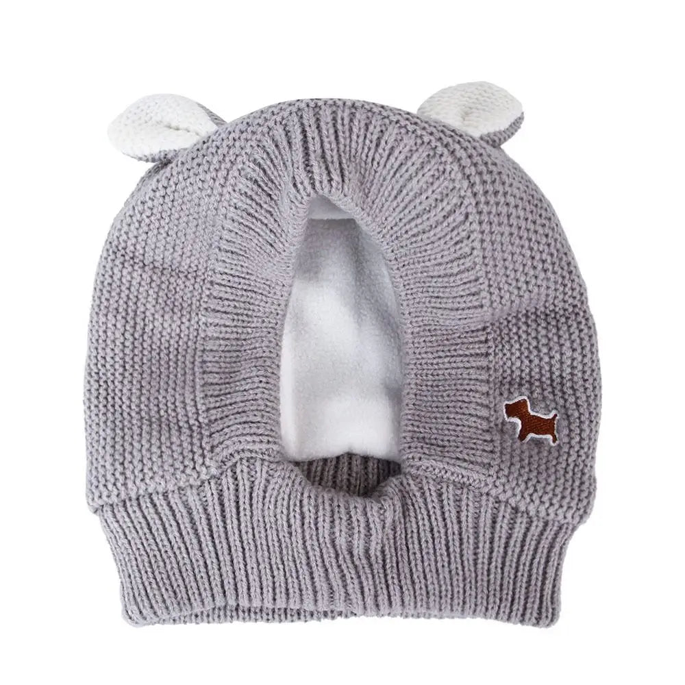 A gray knit beanie with ear muffs and a brown accent patch for dog owners