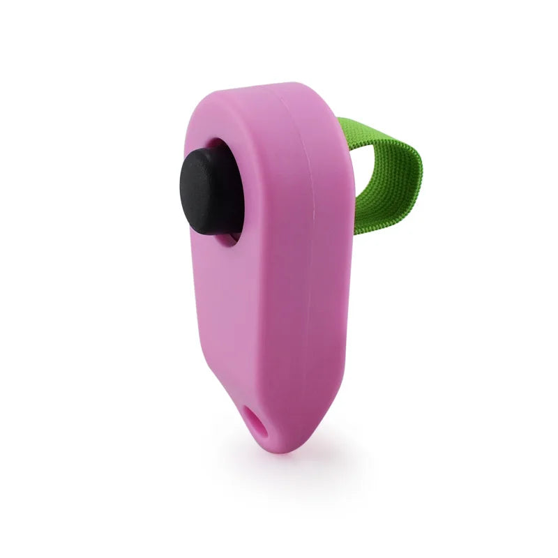 A pink pet training clicker with a black button and a green strap.
