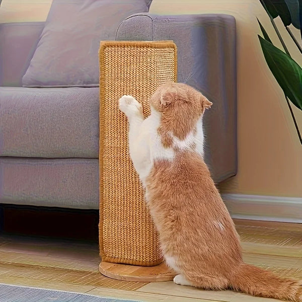 A fluffy orange and white cat is sitting on a natural sisal scratching post next to a gray sofa.