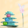 A stack of colorful, interactive cat turntable toys with rolling balls and a pink feather wand against a light background.