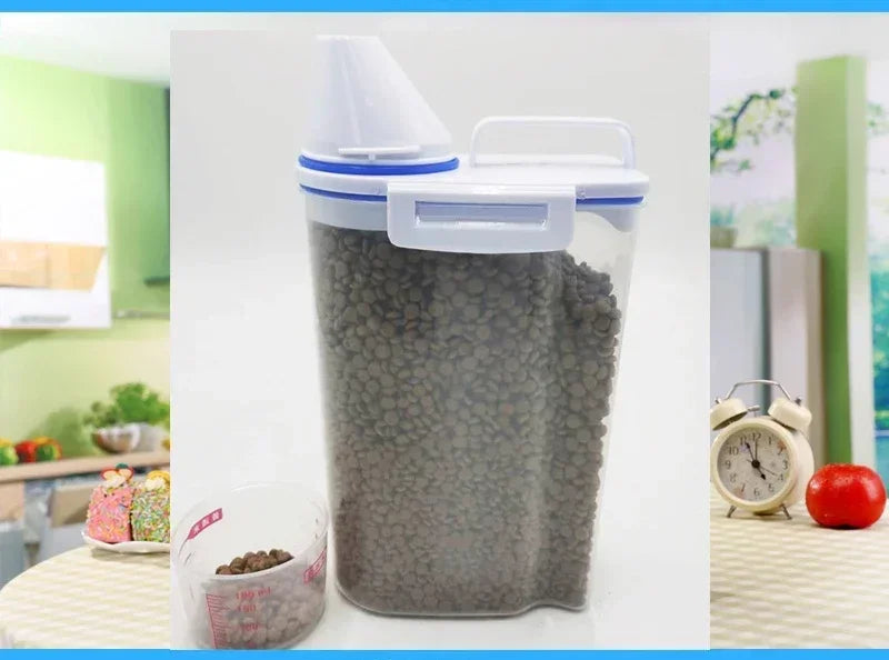 A clear airtight pet food storage container filled with dry kibble and a measuring cup nearby.