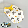 White dog print vest with yellow trim and a yellow tag on a light gray background.