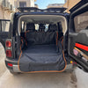 Black waterproof pet car seat cover installed in the rear cargo area of a vehicle.