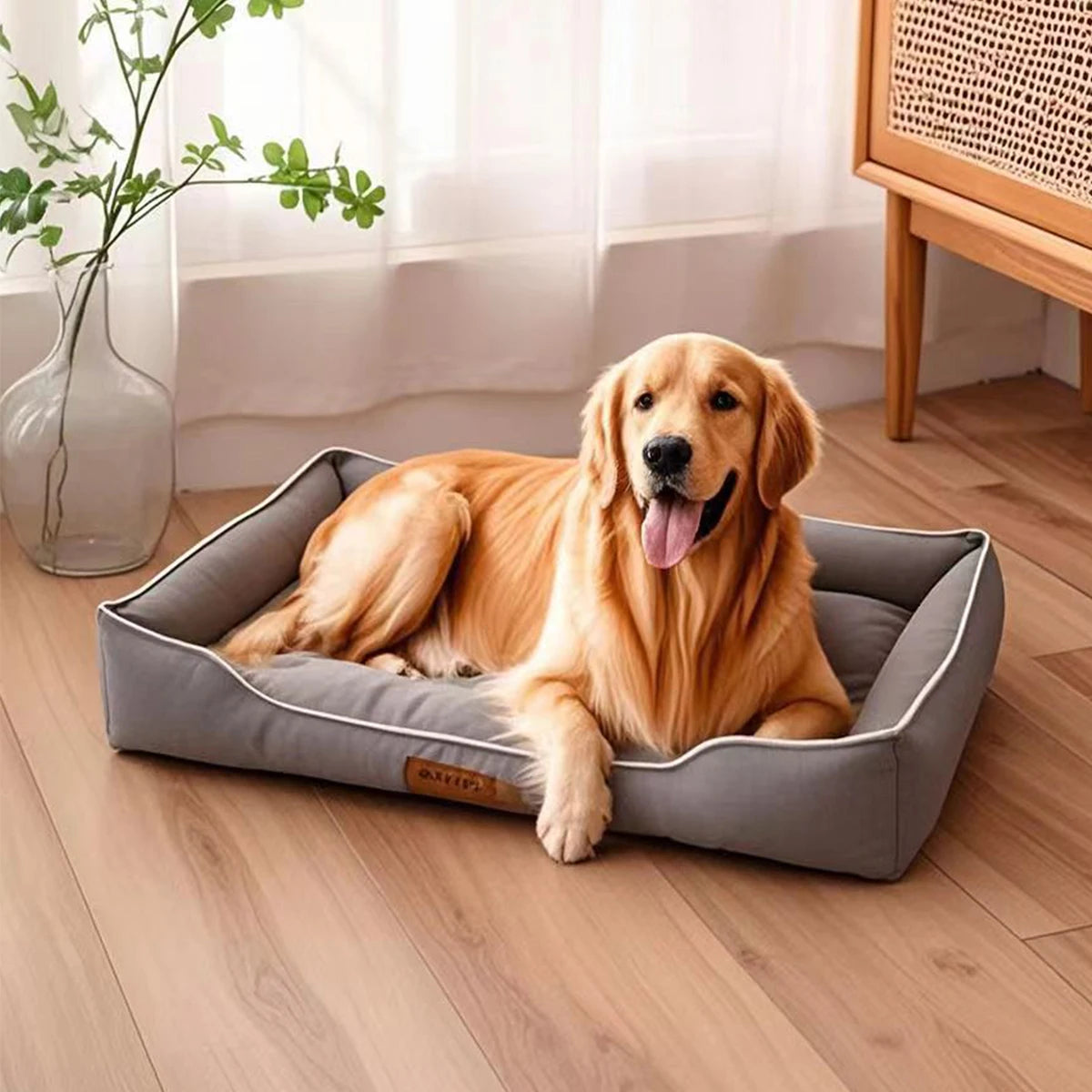 A golden retriever lies comfortably on a gray orthopedic dog bed indoors.
