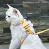 Un gato blanco vistiendo un arnés y correa de abeja de dibujos animados amarillo.