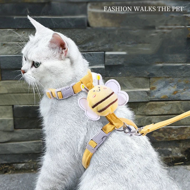 Un gato blanco vistiendo un arnés y correa de abeja de dibujos animados amarillo.