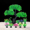 Un árbol artificial en miniatura con follaje verde vibrante y varias plantas en macetas pequeñas sobre una superficie blanca.
