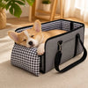 A small, fluffy orange and white dog is resting inside a gray foldable dog car seat with a checkered fabric insert.