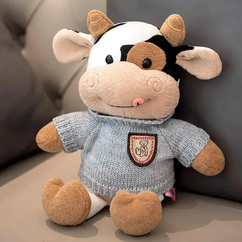 A soft cow plush toy with white and black markings, featuring large ears and a friendly expression.