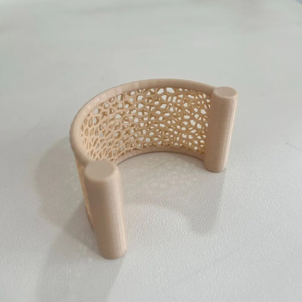 A light beige 3D printed floating betta hammock for aquarium decor, featuring a perforated design.